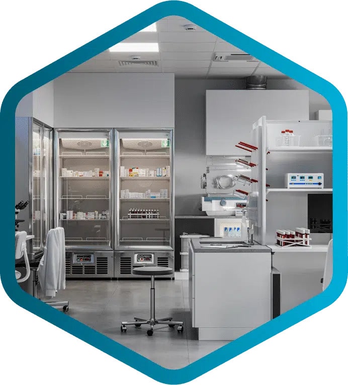 Modern laboratory with refrigerators, lab equipment, shelves holding bottles and containers, a stool, and white walls, all seen within a blue hexagonal frame.